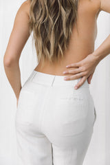 Close-up of back pocket details on white linen trousers