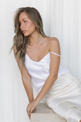 Woman wearing white silk camisole and cream silk slip skirt