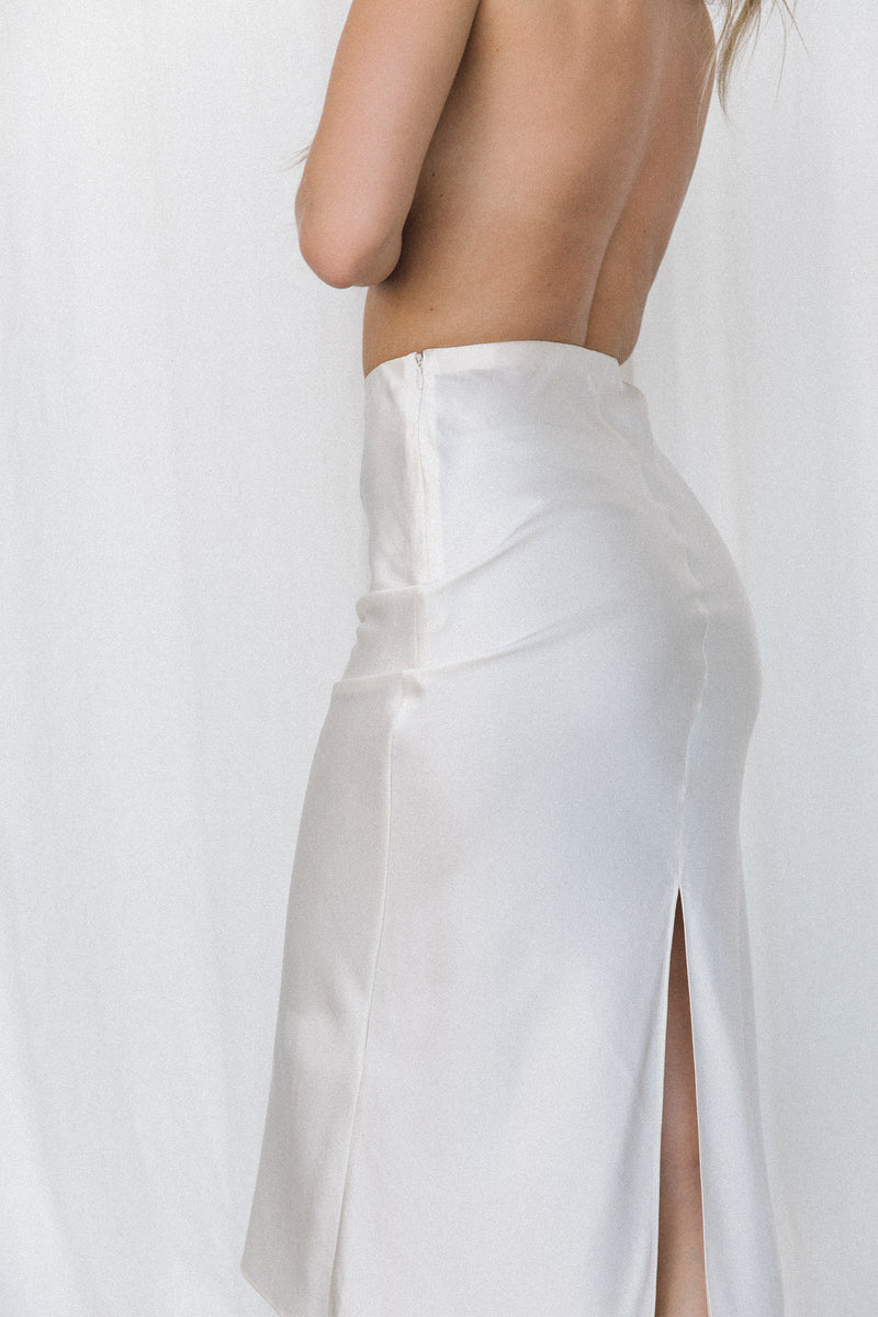 Close-up of model wearing cream silk slip skirt posing in a studio